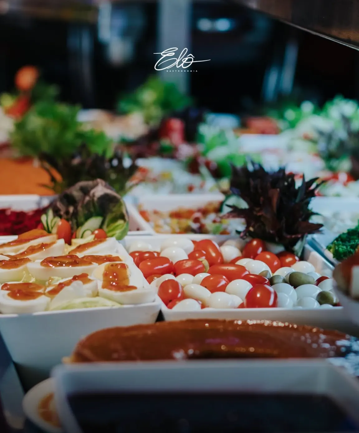 Mesa de buffet com ovos, tomates e acompanhamentos
