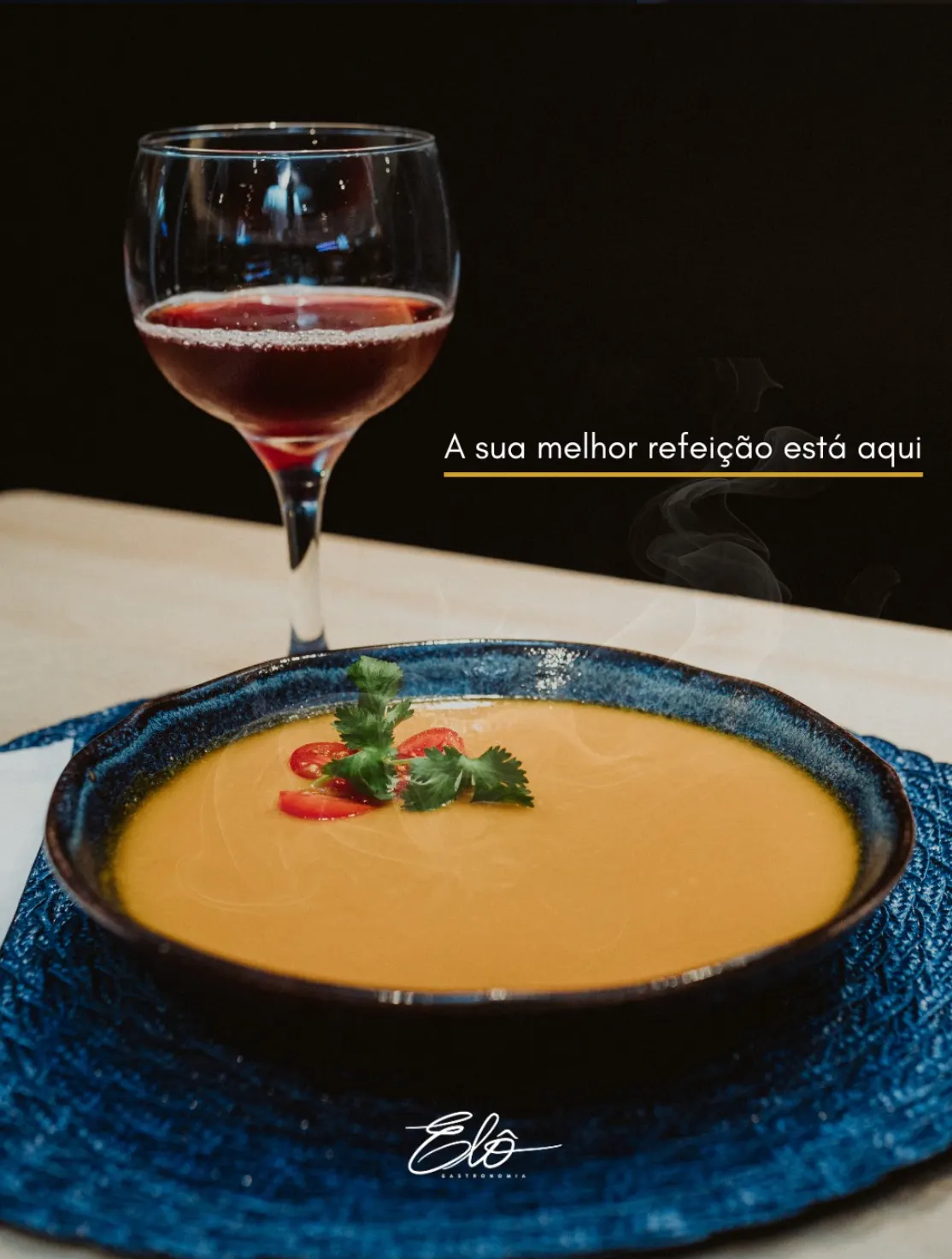 Sopa cremosa servida com taça de vinho